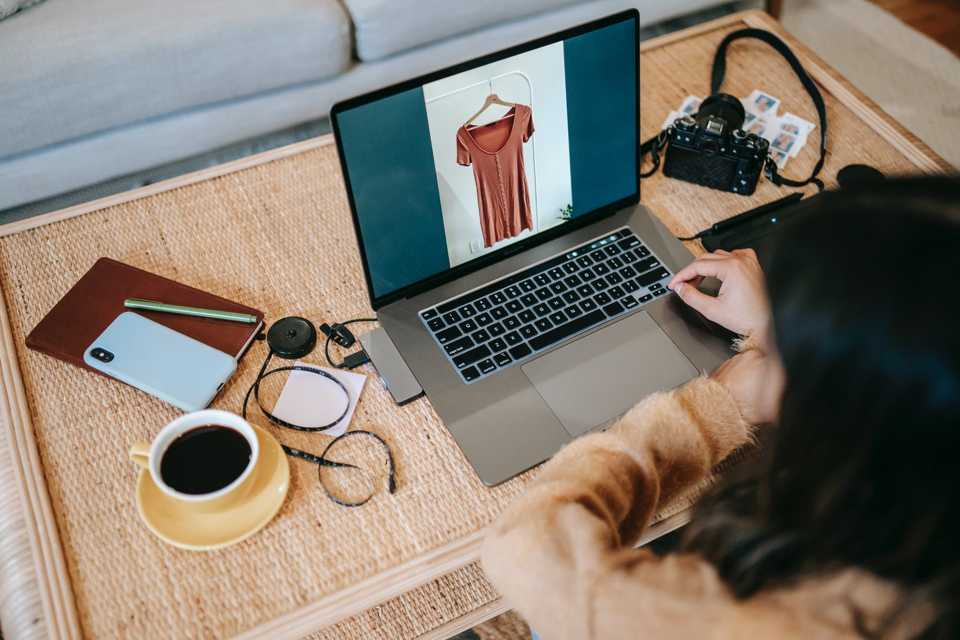 crop photographer using laptop with photo on screen near coffee